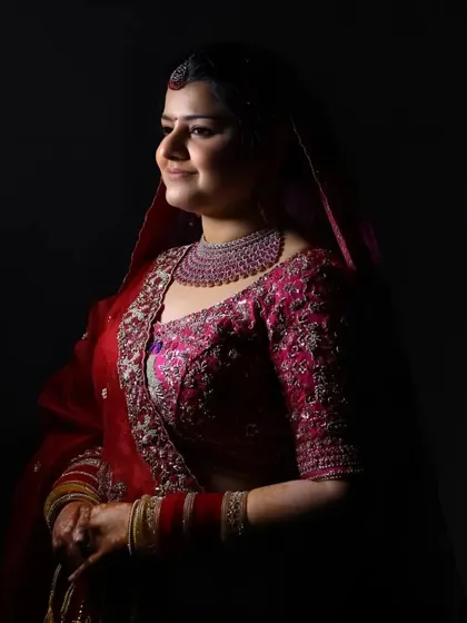 A beautifully lit studio portrait of a bride, with soft light highlighting her features against a dark background.