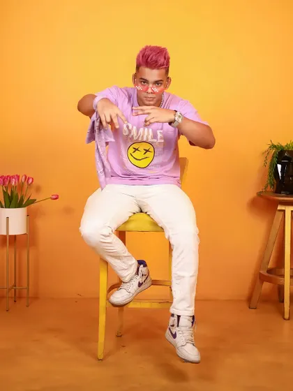 A colorful and playful studio shoot for a male influencer, using a bright orange background.