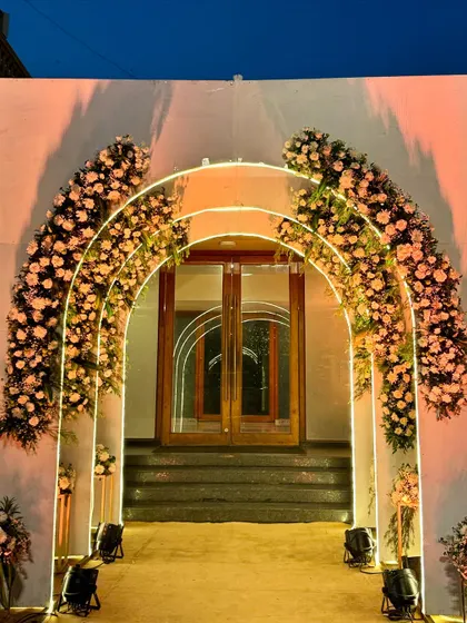 The floral arches captured at dusk, with the sky providing a beautiful natural backdrop. The combination of natural light and the warm artificial glow is simply magical.