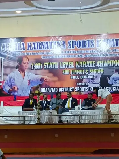 A wide view of the competition area at the 14th State Level Karate Championship, with a match in progress.