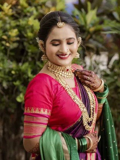 A beautiful, smiling portrait of the bride, with the focus on her happy expression and the details of her necklace and earrings.