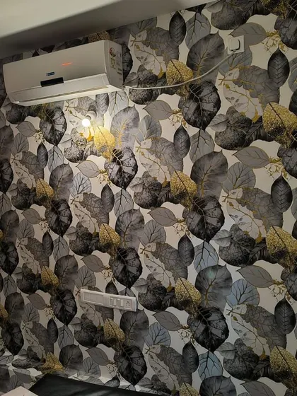 A wallpaper with a dense pattern of grey and yellow leaves, perfect for a cozy bedroom accent wall.