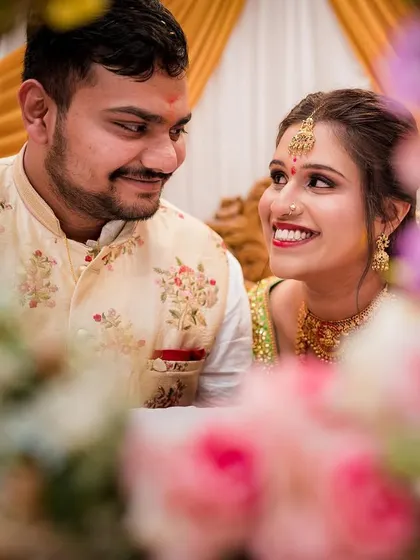 A close-up shot of the couple, framed by flowers, looking at each other with love. These intimate moments are the heart of our photography.