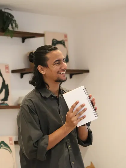 A young poet smiling after his performance at the 'Chai & Poetry' event.