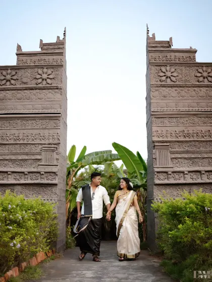 A grand entrance for a filmy couple. The monumental architecture and their coordinated South Indian inspired outfits create a powerful and dramatic pre-wedding photograph.