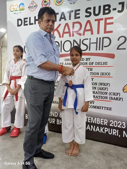 A student receiving her medal at the Delhi State Sub-Junior Karate Championship. Each medal represents a story of perseverance and courage.