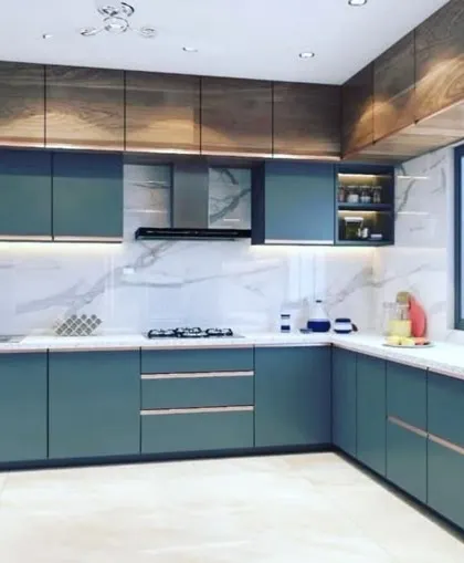 A contemporary kitchen featuring deep teal handleless cabinets paired with rich wood-grain overhead units. The white marble backsplash and countertop brighten the space, while under-cabinet lighting provides excellent task illumination.
