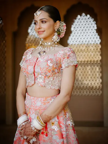 A close-up of the bride's pastel Anand Karaj look, highlighting her fresh makeup and floral hair accessories.