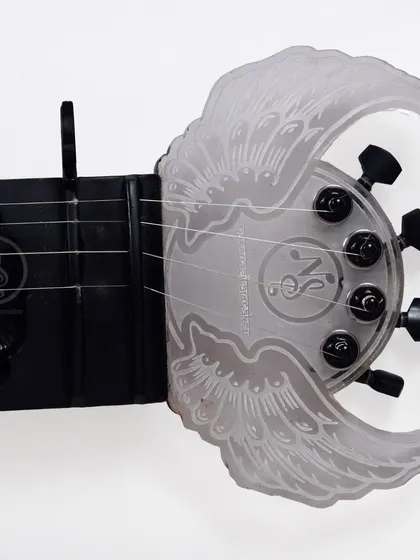 A custom-designed headstock for an electric sitar, featuring an acrylic plate with an angel wings design. We can create any custom design you can imagine.