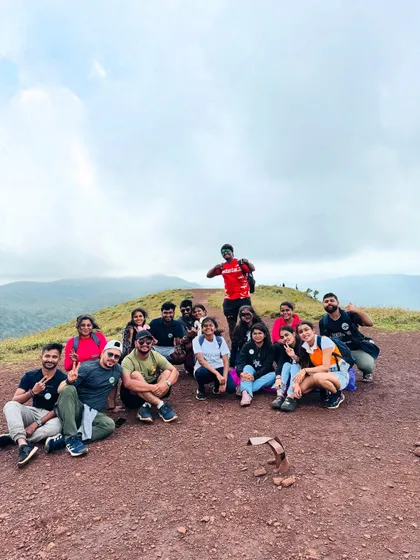 A group relaxing at the top of a hill in Chikmagalur, enjoying the view after a good climb.