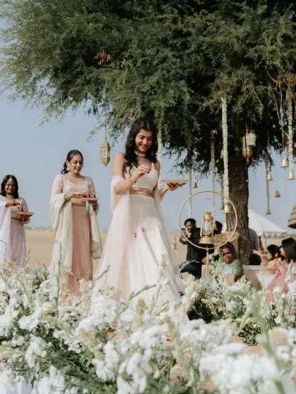 A bridesmaid showering the couple with flowers during the sand dune wedding ceremony.