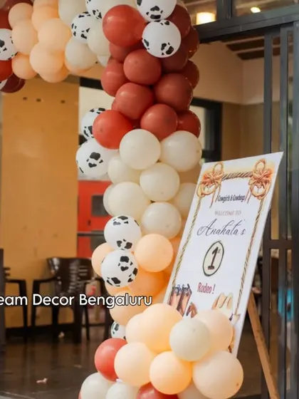 The entrance to the barnyard party, with a balloon arch featuring cow-print balloons.
