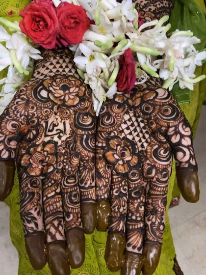 More views of Fathima's bridal henna, showing the personalized name and the stunning floral jewelry that completes the look.