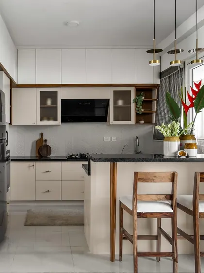 The kitchen in our 'Malhar' project uses a mellow monochrome palette with a light blush tone, beautifully contrasted by warm wooden hues. The result is a calm, sophisticated, and highly functional space.