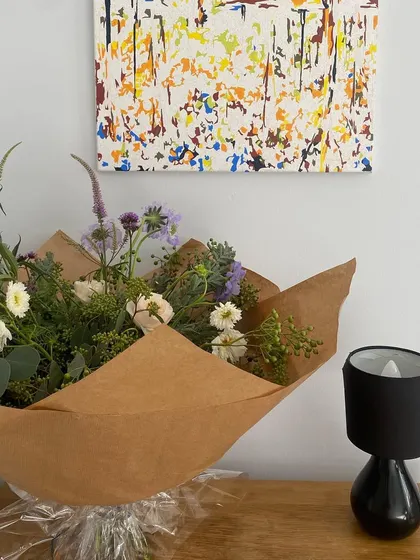 Oh so pretty flowers make for an oh so pretty day. A hand-tied bouquet of wildflowers, wrapped in simple brown paper, showcasing natural and effortless beauty.