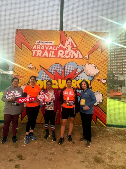 A group of our female runners at the Aravali Trail Run, holding fun props. We celebrate our achievements with joy.