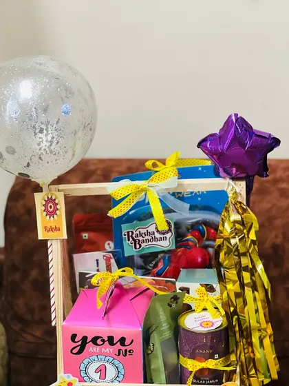 A close-up of the top section of the two-tiered Rakhi hamper, showing the careful arrangement of gifts and decorations.