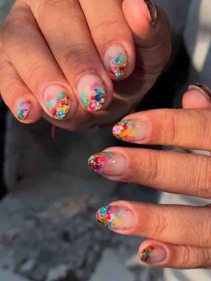 A full view of the playful and vibrant confetti glitter nails.
