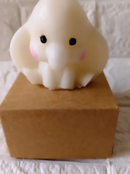 A single, adorable baby elephant candle made from soy wax. This is one of my most requested items for baby shower return favors, shown here with its individual gift box.
