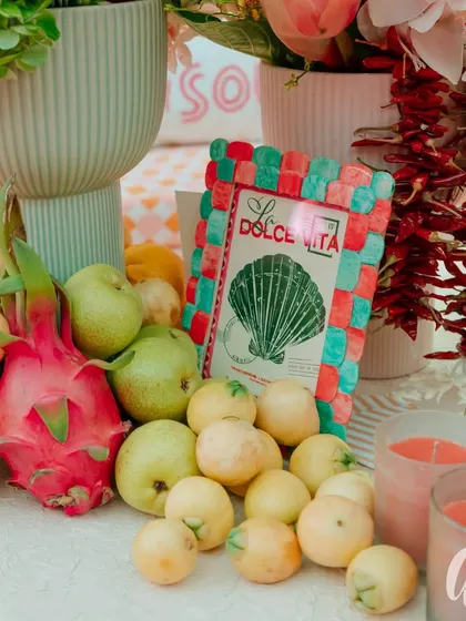 We love incorporating unexpected elements like fresh fruit into our decor. Here, dragon fruit, pears, and guavas add a pop of color and a touch of natural abundance to the tablescape, complementing the Italian theme.