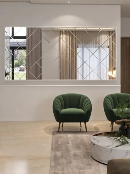 A minimalist living area setup with two striking green scalloped armchairs and a large decorative mirror. The design is clean, modern, and uses accent furniture to create a focal point.