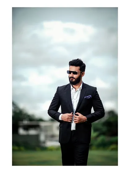 A powerful men's portrait. The subject in a sharp suit against a dramatic sky creates a look of ambition and sophistication.