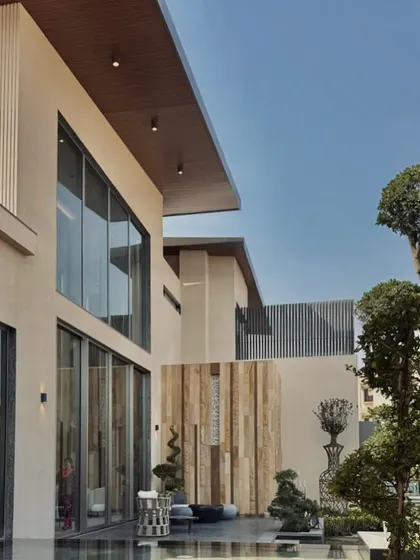 The courtyard of our recently completed residence in Chhattisgarh. The design features a blend of clean lines, natural wood paneling, and curated bonsai trees, creating a tranquil space that harmonizes with the environment.