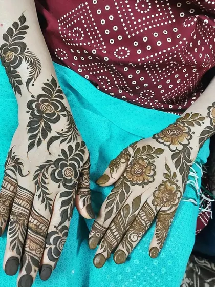 A beautiful example of a two-tone Arabic design. One hand features the fresh, dark henna paste, while the other shows the lovely orange stain after the paste has just been removed.