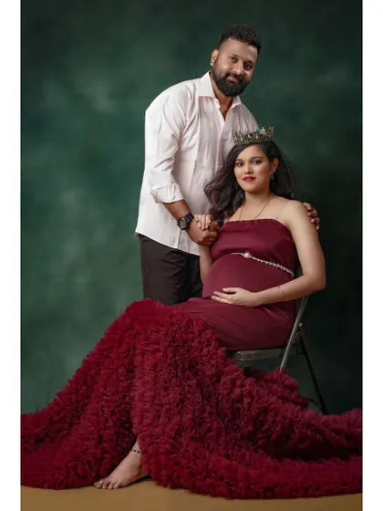 A royal-themed maternity portrait. The mother-to-be wears a crown with our wine-red fishtail gown, creating a powerful and memorable image for her couple's shoot.