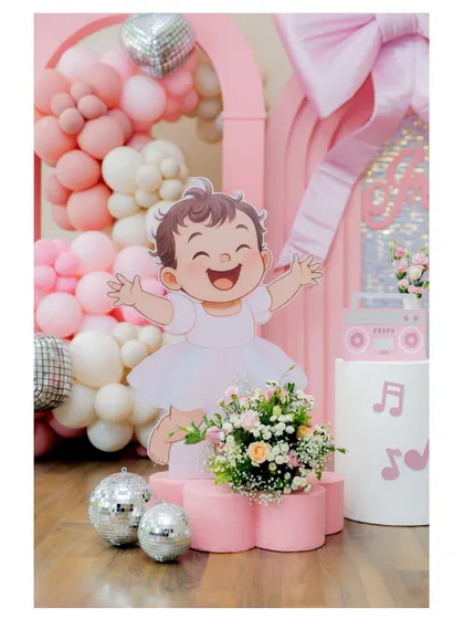 A large, cheerful cutout of a dancing baby, set amongst disco balls and flowers, is the star of this music-themed party.