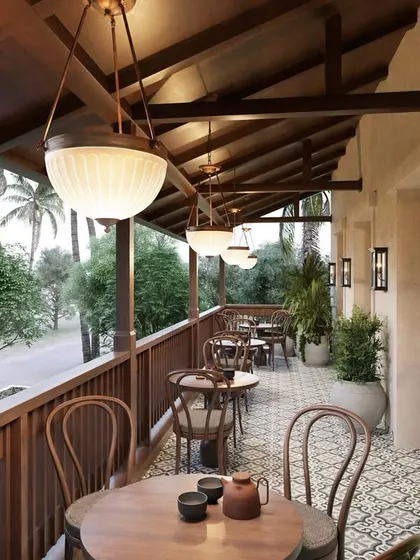 The serene veranda of the cafe is one of my favorite spaces. The warmth of the wooden ceiling and railings, combined with vintage-style lighting and patterned floor tiles, creates a tranquil setting to enjoy the lush views.