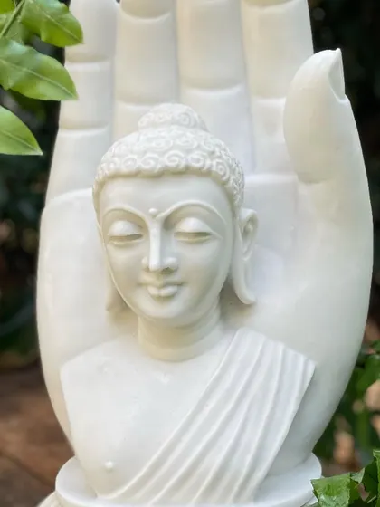 A close-up of our white marble Buddha in a blessing hand, showcasing the purity of the stone and the peaceful expression of the carving.