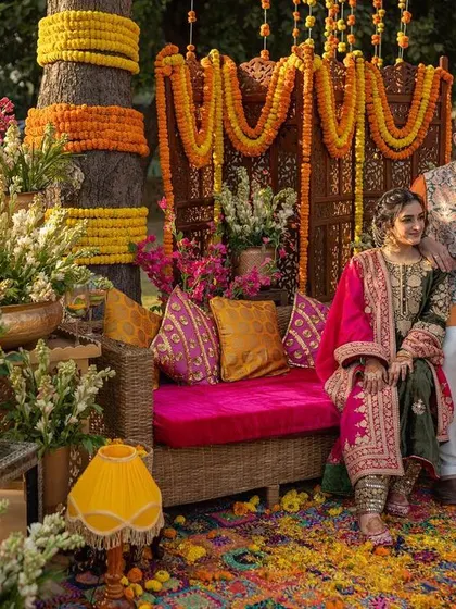 A portrait of the couple amidst the vibrant and folksy decor of their Delhi Mehendi party.