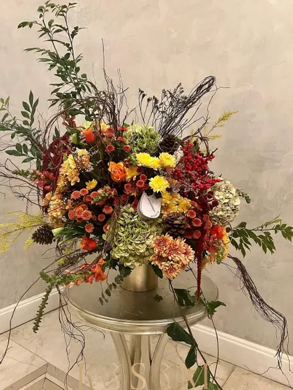 This design is inspired by poetry, for the sophisticated lover of art. It's a wild play of textures and densities in a palette of ochre, maroon, and golden brown, featuring ilex berry, hydrangea, and amaranthus.