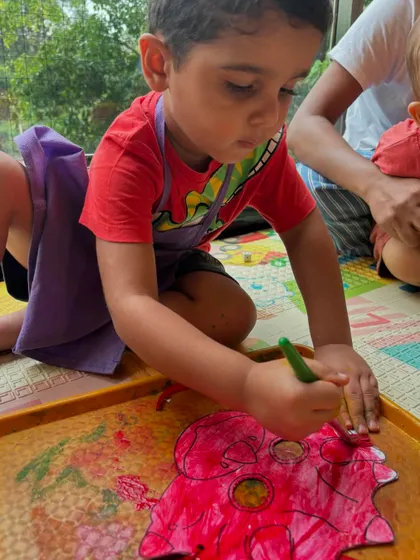 A future paleontologist at work! This child is adding color to a dinosaur cutout, an activity from our Dino-Mite theme week that combines art with learning about these amazing creatures.