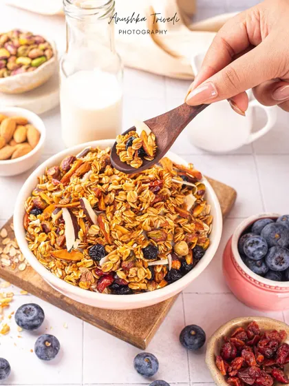 A spoonful of granola being lifted from the bowl, showing off the texture and ingredients up close.
