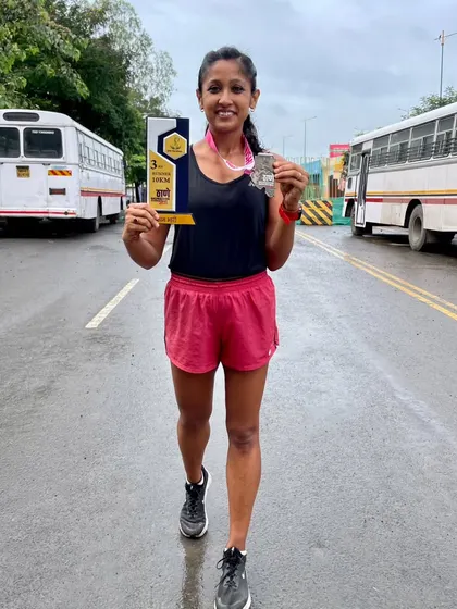 Holding my trophy after a 10km Monsoon Marathon. We compete every day, in every condition.