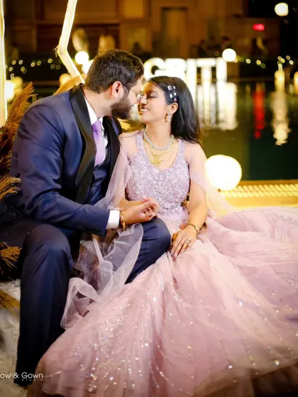 A perfect fairytale moment from an engagement night. The couple shares a sweet, almost-kiss, surrounded by the warm glow of poolside lights, creating a magical and romantic atmosphere.