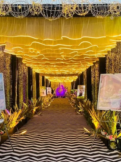 The entrance to the glamorous walkway, framed by golden wire-frame spheres and sequin walls that sparkle in the light.
