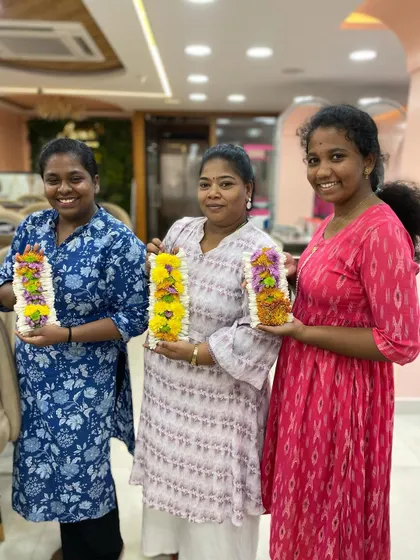 Students proudly displaying the beautiful flower garlands they learned to make in our styling class. This is a valuable add-on service for bridal clients.