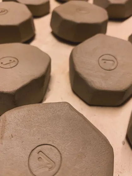 A close-up of the raw, faceted pieces, showing the clean edges and the maker's mark.