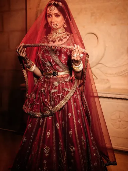 A classic bridal portrait, with the bride looking regal and elegant under her red veil.