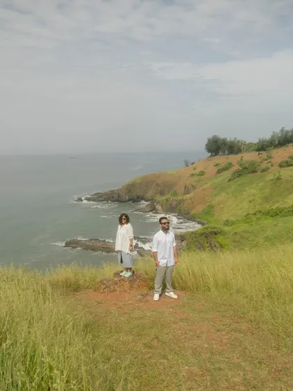 A stunning landscape shot of the couple on a cliff overlooking the Goan coast. It captures the "mountain" feel that the bride wanted for her shoot.