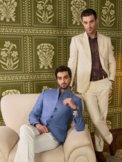 My Irish linen jackets are designed for both work and pleasure. This shot showcases two distinct styles: a blue bandhgala-style jacket and an ivory two-button suit. Both are handcrafted to ensure you stand out with sartorial elegance.