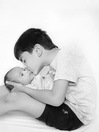 A protective kiss from a big brother. These black and white sibling portraits are timeless and focus purely on the emotional bond between your children.