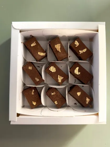 This elegant box contains nine pieces of my decadent chocolate fudge, each adorned with a touch of edible gold leaf. It's a simple, luxurious gift perfect for the Christmas season.
