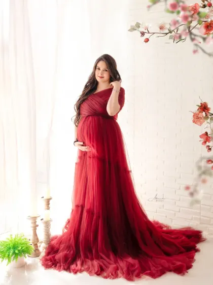 A classic and elegant pose. The mom-to-be looks beautiful in this deep red gown, framed by delicate flowers for a touch of romance.