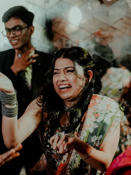 A candid shot of pure joy and laughter from the bride during a Sangeet performance. These are the real, unscripted emotions we aim to preserve.