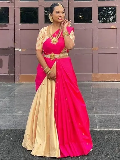 A full-length view of the custom lehenga saree. The combination of the neutral beige skirt and the bright pink dupatta creates a balanced and festive look, perfect for a special celebration.