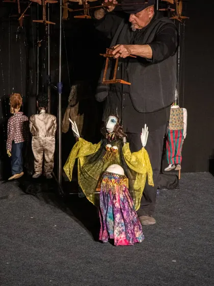 The puppeteer brings the belly dancer marionette to life with skillful manipulation of the strings.